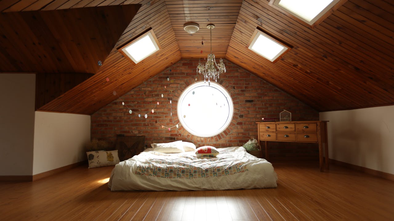 A warm and inviting attic bedroom featuring a unique brick wall and wooden ceiling design.